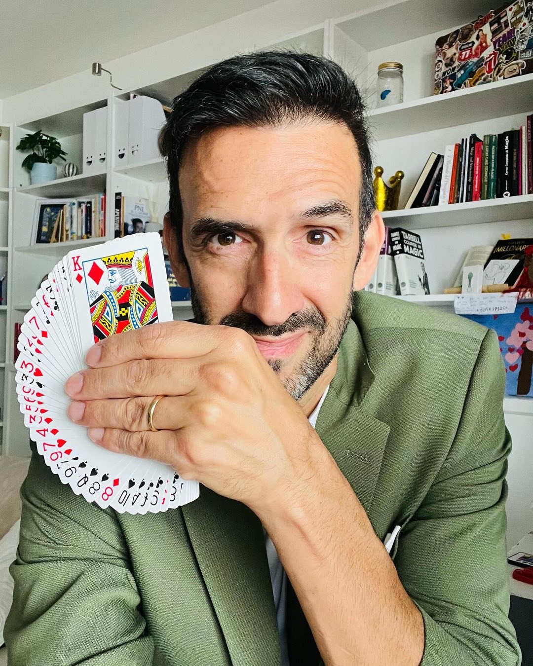 Ritratto di Sergio Starman, illusionista per matrimoni, con un mazzo di carte aperto a ventaglio